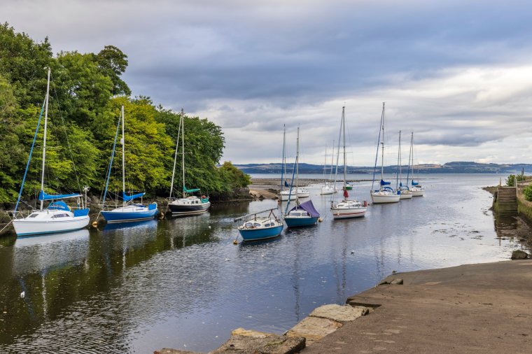 Small boats and yachts moored at the mouth of the River Almond at Cramond near Edinburgh, Scotland.