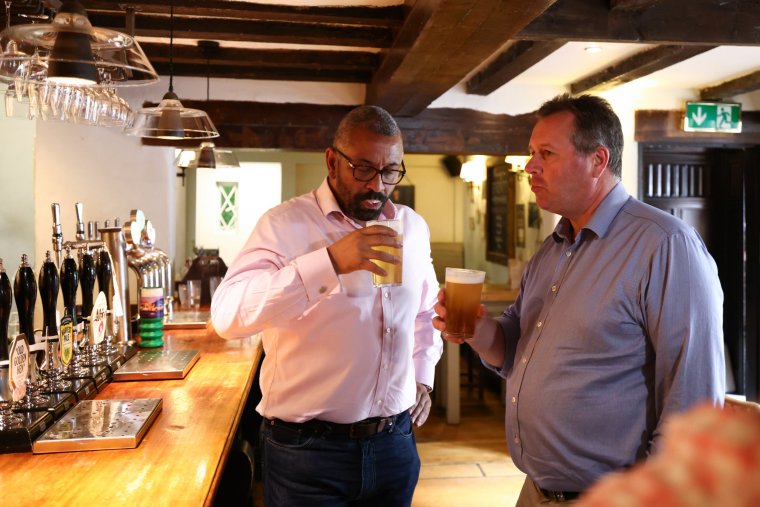 RAVENSHEAD, ENGLAND - JUNE 26: UK Home Secretary James Cleverly (L) and the Conservative candidate for Sherwood Forest Mark Spencer (R) pose with a pint of beer during a General election campaign visit to the Hutt Pub in Ravenshead, on June 26, 2024 in Ravenshead, England. The Prime Minister and Conservative party leader presses on with the final week of campaigning. (Photo by Darren Staples - WPA Pool/Getty Images)