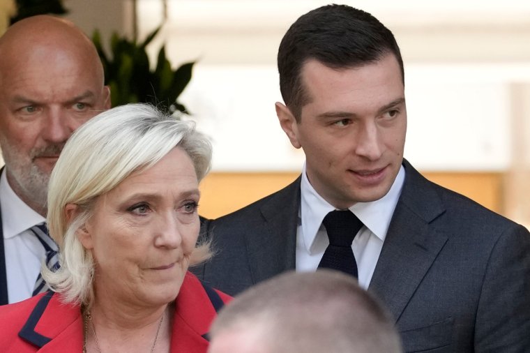 Far-right National Rally party president Jordan Bardella, right, leaves with far-right leader Marine Le Pen after a press conference, Monday, June 24, 2024 in Paris. The upcoming two-round parliamentary election will take place on June 30 and July 7. (AP Photo/Christophe Ena)