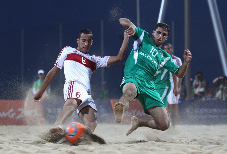 HAIYANG, CHINA - JUNE 21: Mohamad Mechleb Matar of Lebanon is tackled by Mohammed Barakat of Palestine during the Beach Soccer Men's Bronze Medal Match between Palestine and Lebanon on Day 5 of the 3rd Asian Beach Games Haiyang 2012 at Fengxiang Beach on June 21, 2012 in Haiyang, China. (Photo by Ryan Pierse/Getty Images)