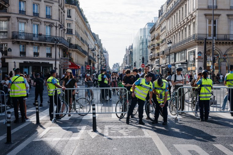 French Gendarmerie officers check pedestrians and cyclists QR codes and luggages at a barriers checkpoint to circulate near the Louvre Museum in Paris on July 18, 2024, ahead of the opening ceremony of the Paris 2024 Olympic Games. French security forces began locking down large parts of central Paris on July 18, 2024, ahead of the hugely complex Olympics opening ceremony the week after on the river Seine. The opening parade along six kilometres (four miles) of the river led to the closure of riverside central districts to most vehicles from 5:00 am (0300 GMT) on July 18. (Photo by Dimitar DILKOFF / AFP) (Photo by DIMITAR DILKOFF/AFP via Getty Images)