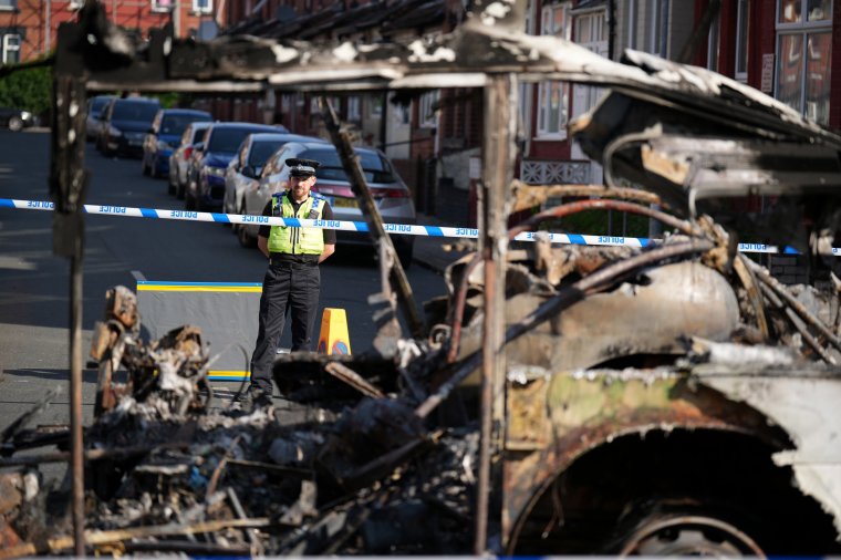 LEEDS, ENGLAND - JULY 19: Police tape cordons off the remains of a burnt out bus after civil disturbance last night on July 19, 2024 in Leeds, England. Riots took hold in the Harehills area of Leeds last night, reportedly after children were forcibly removed from their family and taken into care. (Photo by Christopher Furlong/Getty Images)