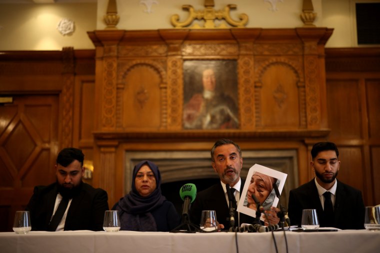 MANCHESTER, ENGLAND - AUGUST 6: Solicitor Aamer Anwar (2-R) holds up a photo showing bruising on 56-year-old Shameem Akhtar's face, as he is accompanied by brothers Muhammad Amaad (L), Fahir Amaaz (R) and their mother, Shameem Akhtar (2-L), during a press conference at the Midland Hotel on August 6, 2024 in Manchester, England. The brothers were involved in an incident on July 23rd at Manchester Airport, during which one of the men was kicked and stamped on by an officer. That officer was later suspended pending an investigation, although the police department says the man first struck their officers. Their solicitor says they will file a formal complaint with the Independent Office for Police Conduct (IOPC). (Photo by Dan Kitwood/Getty Images)