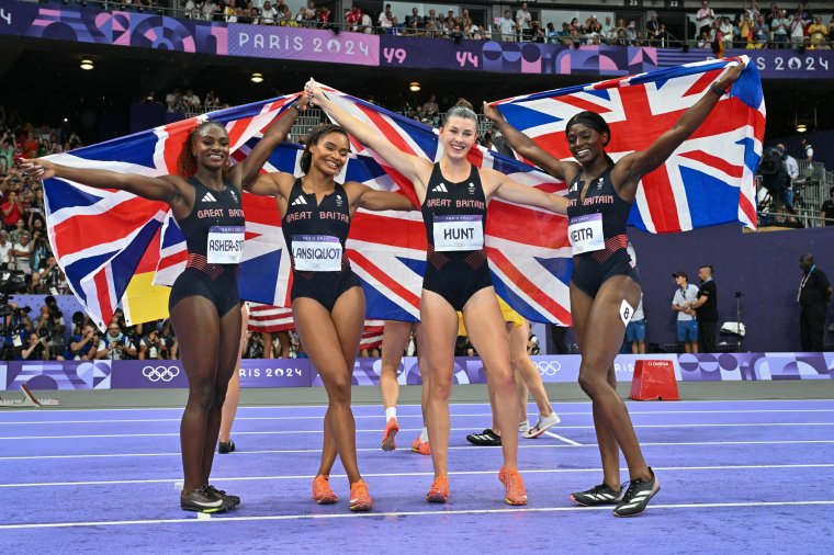 Silver medallists Dina Asher-Smith, Imani Lansiquot, Amy Hunt and Daryll Neita of team Great Britain celebrate after the women's 4x100m relay final of the athletics event at the Paris 2024 Olympic Games at Stade de France in Saint-Denis, north of Paris, on August 9, 2024. (Photo by Andrej ISAKOVIC / AFP) (Photo by ANDREJ ISAKOVIC/AFP via Getty Images)