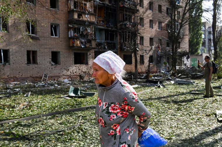 An elderly woman walks past an apartment building damaged after shelling by the Ukrainian side in Kursk, Russia, Sunday, Aug. 11, 2024. (AP Photo)