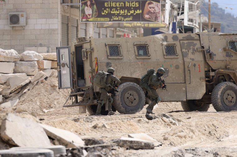 Israeli soldiers operate during a raid in the Nur Shams camp for Palestinian refugees near the city of Tulkarem in the Israeli-occupied West Bank on August 28, 2024. At least 10 Palestinians were killed in Israeli raids and strikes in several towns in the north of the occupied West Bank, a spokesman for the Red Crescent said on August 28. The operation comes two days after Israel said it carried out an air strike on the West Bank that the Palestinian Authority reported killed five people. (Photo by JAAFAR ASHTIYEH / AFP) (Photo by JAAFAR ASHTIYEH/AFP via Getty Images)