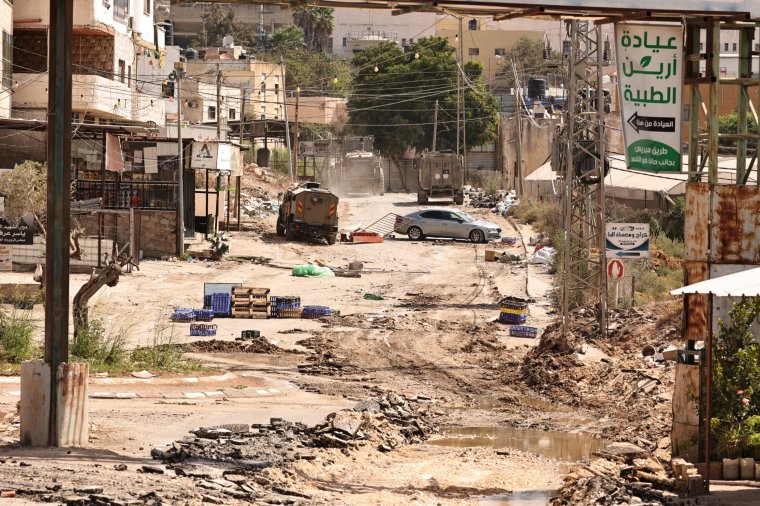 Israeli military armoured vehicles drive down a road during a raid in the al-Faraa camp for Palestinian refugees near Tubas city in the occupied West Bank on August 28, 2024. The Israeli army targeted four cities as it launched a major operation in the occupied West Bank on August 28, with the Palestinian Red Crescent reporting at least 10 dead. (Photo by Zain JAAFAR / AFP) (Photo by ZAIN JAAFAR/AFP via Getty Images)