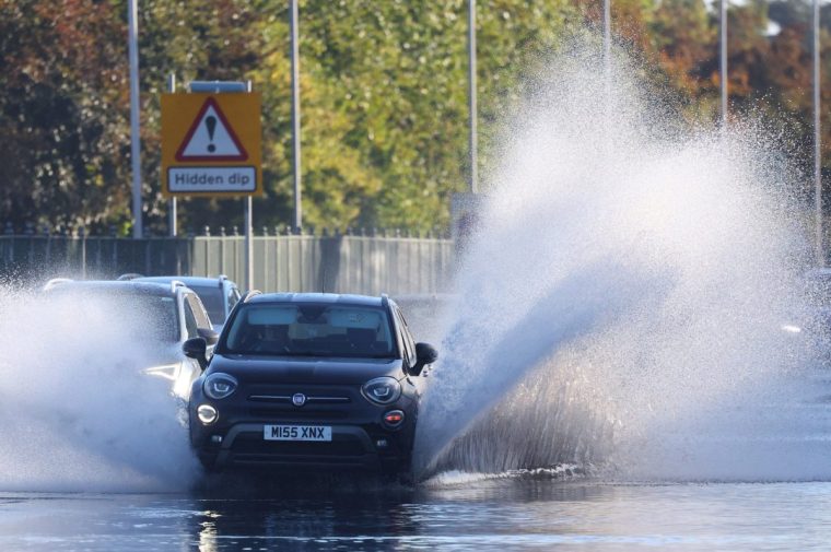 Cars drive along a flooded road as heavy rain continues to cause flooding in areas of the country, in southwest London, Britain, September 26, 2024. REUTERS/Toby Melville