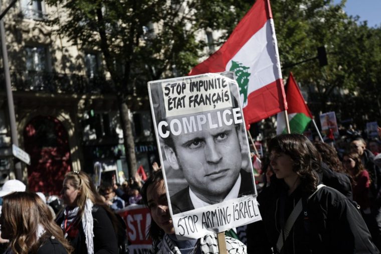 A woman holds a placard reading in French "Stop impunity. French state accomplice" is the cradle of anti-Semitism" take part in a rally ogarnised by the association France Palestine Solidarite (AFPS) in support of the Palestinian people, in Paris, on October 5, 2024. (Photo by STEPHANE DE SAKUTIN / AFP) (Photo by STEPHANE DE SAKUTIN/AFP via Getty Images)