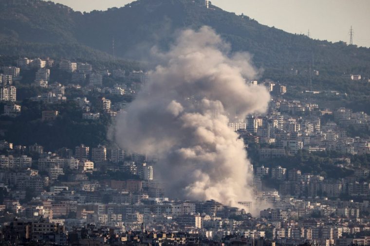 TOPSHOT - Thick smoke billows over buildings following an Israeli airstrike on Beirut's southern suburbs on October 19, 2024, amid the ongoing war between Israel and Hezbollah. (Photo by ANWAR AMRO / AFP) (Photo by ANWAR AMRO/AFP via Getty Images)