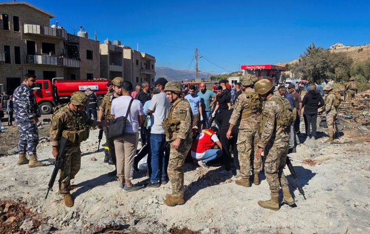 Lebanese army soldiers and people stand at the site of an Israeli strike in the town of Baaloul, in the western Bekaa Valley, Lebanon October 19, 2024. REUTERS/Maher Abou Taleb