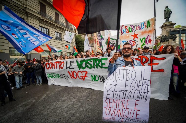 Demonstrators hold a banner which read as "Against the G7, wars and all the states, always and everywere freedom", as the Group of Seven (G7) Defence Ministers summit is being held, in Naples on October 19, 2024. The G7 Defence Ministers -- from Italy, France, Germany, Britain, Japan, Canada and the United States -- warned of the dangers of further intensification in the Middle East, including in Lebanon where the United Nations has blamed Israel for strikes on UN peacekeepers. (Photo by ANSA / ANSA / AFP) / Italy OUT (Photo by ANSA/ANSA/AFP via Getty Images)