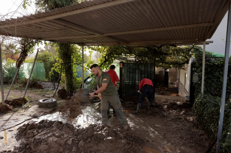 People remove the mud of a house after heavy rains and floods in Alora, Spain October 29, 2024. REUTERS/Jon Nazca