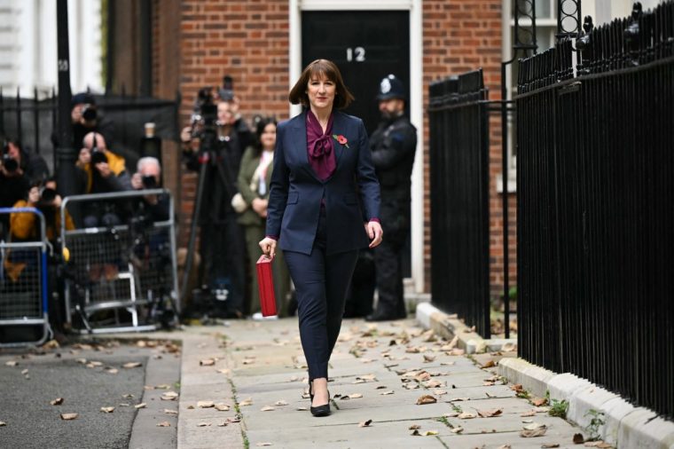 TOPSHOT - Britain's Chancellor of the Exchequer Rachel Reeves carries the red Budget Box as she leaves 11 Downing Street, in central London, on October 30, 2024, to present the government's annual Autumn budget to Parliament. Britain's new Labour government unveils its first budget on Wednesday, the highly-anticipated fiscal update, the first under the centre-left government after 14 years of Conservative rule. (Photo by JUSTIN TALLIS / POOL / AFP) (Photo by JUSTIN TALLIS/POOL/AFP via Getty Images)