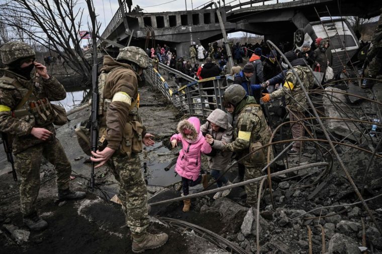 UKRAINE - RUSSIA CONFLICT 100 DAYS 100 PICTURES AFP presents a selection of 100 pictures to mark 100 days of Russia's war in Ukraine People cross a destroyed bridge as they evacuate the city of Irpin, northwest of Kyiv, during heavy shelling and bombing on March 5, 2022, 10 days after Russia launched a military in vasion on Ukraine. (Photo by Aris Messinis / AFP) / UKRAINE - RUSSIA CONFLICT 100 DAYS 100 PICTURES (Photo by ARIS MESSINIS/AFP via Getty Images)