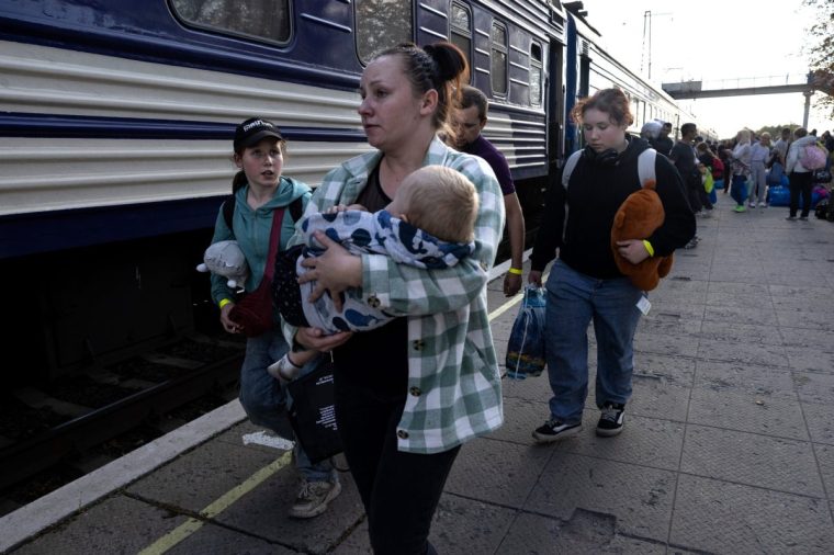 PAVLOHRAD, UKRAINE- OCTOBER 10: Natalia Pavluchenko carries her 16 month old son Denis as her family heads to board a refugee train on October,10 2024 in Pavlohrad, Ukraine. Residents of front line areas of Pokrovsk, Myrnohard and Kurakove were forced to flee as the area has been hit by intense Russian bombardment over weeks now, many waiting to leave until the last moment. Pokrovsk has no electricity, gas or water supply and the city is under constant curfews making life unbearable and too dangerous. (Photo by Paula Bronstein/Getty Images)