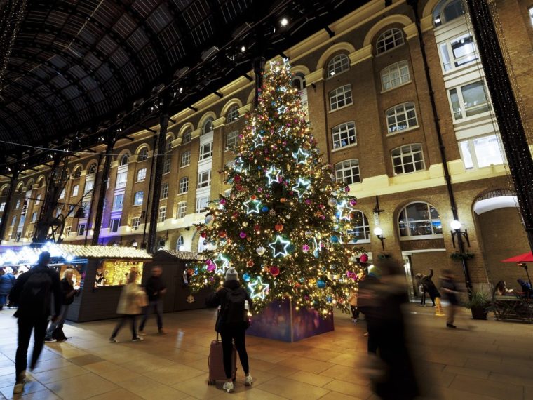 UK, London, indoor Christmas market with decorated Christmas tree in Hay's Galleria illuminated at night