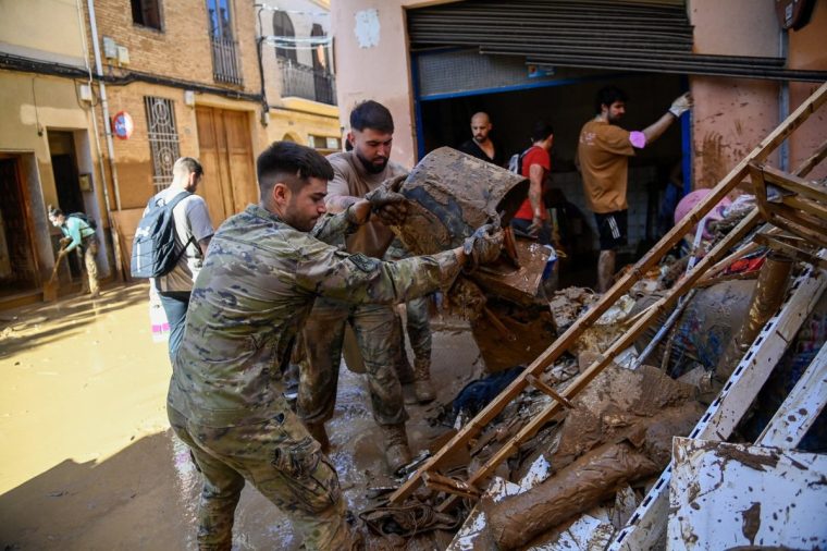 Members of the military work to clear mud and debris in the town of Catarroja, in the region of Valencia, eastern Spain, on November 2, 2024, in the aftermath of devastating floolding. Rescuers have raised the death toll in Spain's worst floods for a generation to 205 and fears grew for the dozens missing as hopes of finding survivors fade. (Photo by JOSE JORDAN / AFP) (Photo by JOSE JORDAN/AFP via Getty Images)