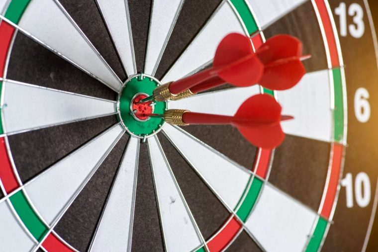 Red three darts in the target centre business goal concept.