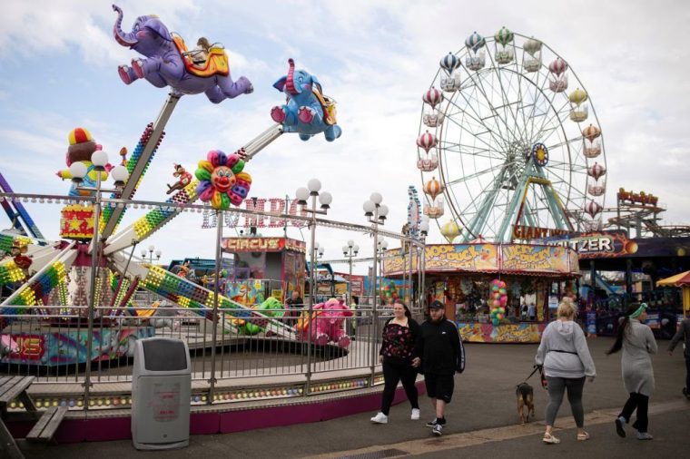 Members of the public make their way through the Pleasure Beach in Skegness, England, on June 11, 2024. Britain goes to the polls on July 4, 2024 in a general election that looks set to end 14 years of Conservative rule marked by economic turbulence, Brexit, political scandal and upheaval. (Photo by Oli SCARFF / AFP) (Photo by OLI SCARFF/AFP via Getty Images)