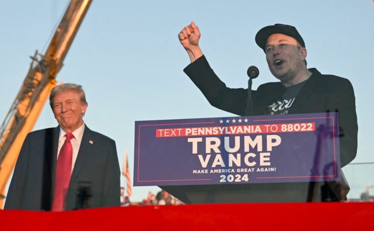 (FILES) Tesla CEO Elon Musk (R) speaks on stage as he joins former US President and Republican presidential candidate Donald Trump during a campaign rally at site of his first assassination attempt in Butler, Pennsylvania on October 5, 2024. Donald Trump announced Nvember 12, 2024 that the world's richest man, Elon Musk, will lead a new US government efficiency group tasked with cutting federal waste, as the Republican president-elect added a series of seasoned figures and hardliners to his incoming administration. Musk became a key ally to Trump during his campaign, reportedly spending over $100 million to help the Republican win and repeatedly boosting Trump's candidacy on X, the platform he owns. (Photo by Jim WATSON / AFP) (Photo by JIM WATSON/AFP via Getty Images)