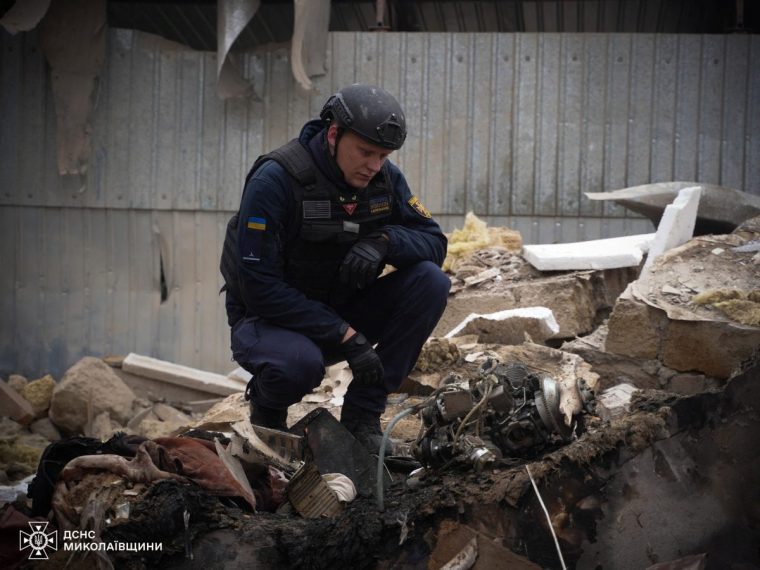 An emergency service officer inspects part of a kamikaze drone on debris of a residential house damaged during a Russian drone strike, amid Russia's attack on Ukraine, in Mykolaiv, Ukraine November 17, 2024. Press service of the State Emergency Service of Ukraine in Mykolaiv region/Handout via REUTERS ATTENTION EDITORS - THIS IMAGE HAS BEEN SUPPLIED BY A THIRD PARTY. DO NOT OBSCURE LOGO.