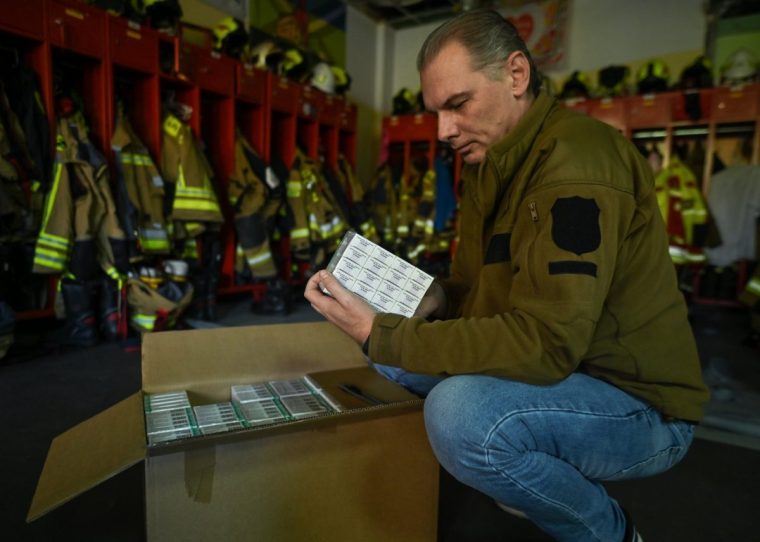 MILANOWEK, POLAND - OCTOBER 10: Marcin Rossak, a local firefighter opens a box of iodine tablets in Milanowek Fire station, one of the distribution points, in Milanowek, Poland on October 10, 2022. The Pharma 65 mg drug is a prescription medicine that is intended for use in the event of nuclear disasters or nuclear reactor failures where radioactive iodine emission may occur. (Photo by Artur Widak/Anadolu Agency via Getty Images)