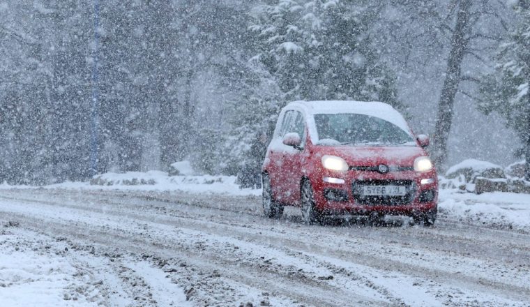 A car drives through the snow in Aviemore, Scotland, Britain November 21, 2024 REUTERS/Russell Cheyne