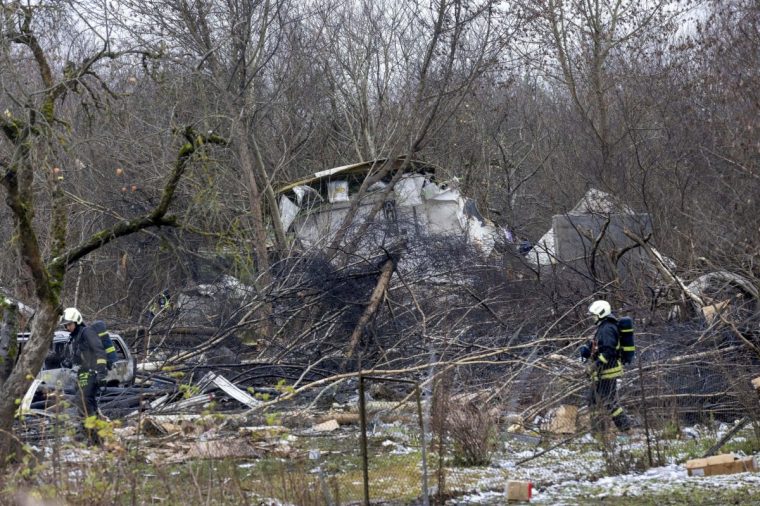 Lithuanian Emergency Ministry employees work at the site where a DHL cargo plane crashed into a house near Vilnius, Lithuania, Monday, Nov. 25, 2024. (AP Photo/Mindaugas Kulbis)