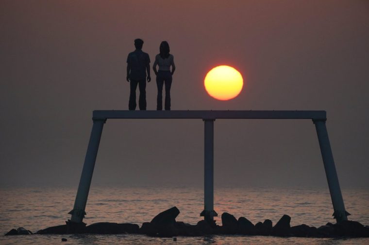 The sunrises through the sea mist over the sculpture "The Couple" by Sean Henry at Newbiggin-by-the-Sea on the Northumberland coast. Picture date: Monday February 13, 2023. PA Photo. Photo credit should read: Owen Humphreys/PA Wire