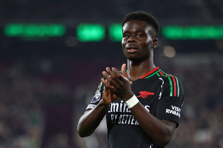 Arsenal's English midfielder #07 Bukayo Saka applauds during the English Premier League football match between West Ham United and Arsenal at the London Stadium, in London on November 30, 2024. (Photo by HENRY NICHOLLS / AFP) / RESTRICTED TO EDITORIAL USE. No use with unauthorized audio, video, data, fixture lists, club/league logos or 'live' services. Online in-match use limited to 120 images. An additional 40 images may be used in extra time. No video emulation. Social media in-match use limited to 120 images. An additional 40 images may be used in extra time. No use in betting publications, games or single club/league/player publications. / (Photo by HENRY NICHOLLS/AFP via Getty Images)