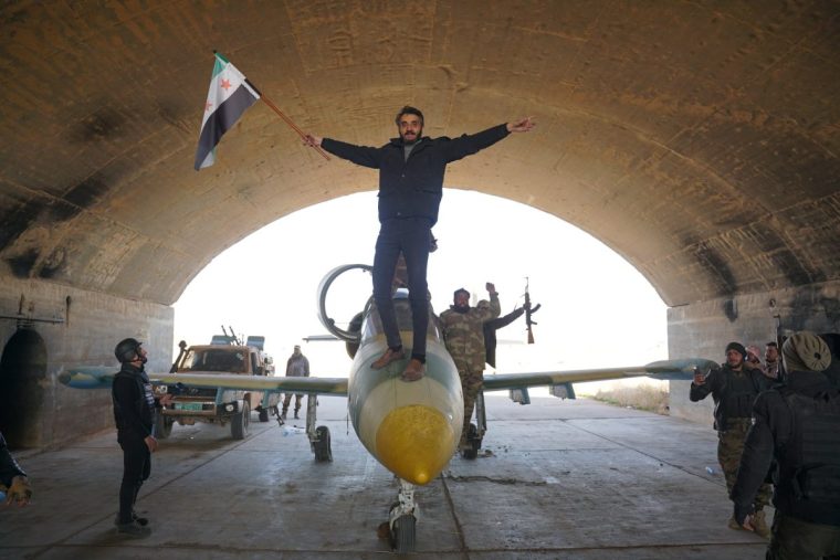 ALEPPO, SYRIA - DECEMBER 01: A soldier of Syrian National Army (SNA) poses with the flag on the plane after taking control of Kuwairis Military Airport, east of Aleppo, as the advance of Operation Dawn of Freedom, an operation launched against the PKK, listed as a terrorist organization by Turkiye, the U.S. and the EU, and YPG, which Turkiye consider as the extension of PKK in Syria, between Tel Rifat and Manbij on December 01, 2024 in Aleppo, Syria. As part of the operation, the SNA has captured Tel Rifat's villages of Shagoreet, Tebnah, Al-Malikiyah, Kafr Kalbin, Kafr Naya, Miskan, Al-Ghuz, Tatmuras, Tal Anab, Mazraat Hamad, Zouyan, Maaranaz, and Zouyan Hill. (Photo by Mustafa Bathis/Anadolu via Getty Images)