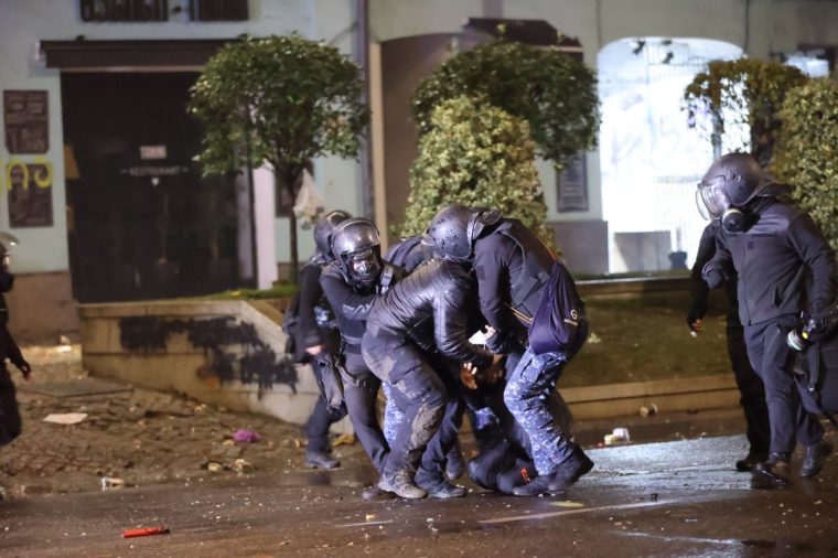 TBILISI, GEORGIA - DECEMBER 02: Protesters set garbage cans on fire and use pyrotechnics against the police while the police uses tear gas as they clash during a protest against the decision to suspend Georgia's EU accession negotiations until 2028 on December 2, 2024 in Tbilisi, Georgia. (Photo by Davit Kachkachishvili/Anadolu via Getty Images)