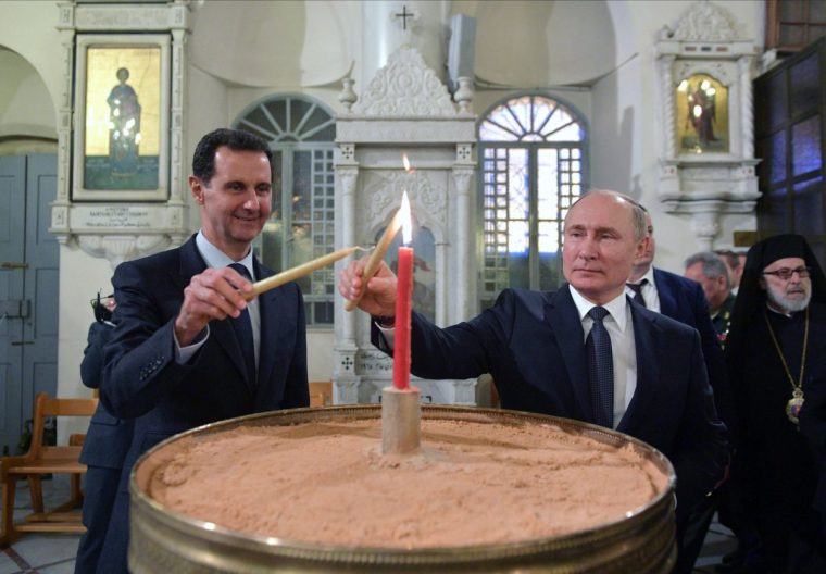 FILE - Russian President Vladimir Putin, right, and Syrian President Bashar Assad light candles while visiting an orthodox cathedral for Christmas, in Damascus, Syria, Jan. 7, 2020. (Alexei Druzhinin, Sputnik, Kremlin Pool Photo via AP, File)