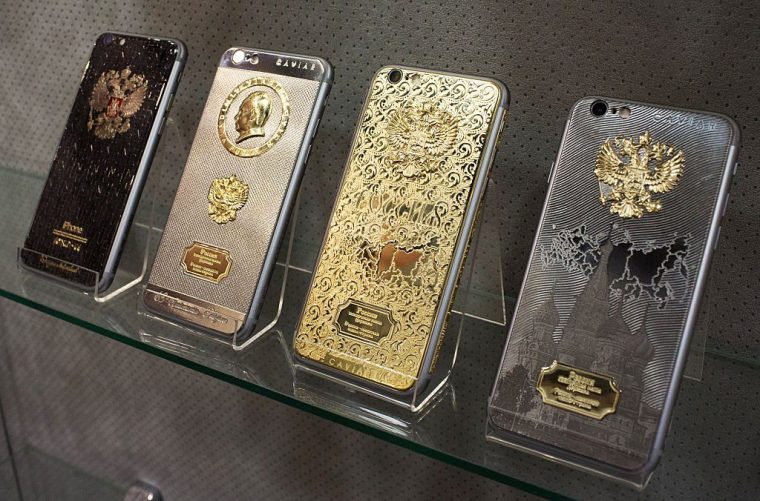 The profile of Vladimir Putin, Russia's president, sits on the rear casing of an 18 carat gold plated 'Ti Gold Supremo Putin' bespoke Apple Inc. iPhone 6s, second left, displayed at the Caviar Boutique at the Zhukovka Plaza shopping centre in Moscow, Russia, on Wednesday, Oct. 21, 2015. Russian policy makers have struggled to concoct the right policy mix to steer the country out of its longest recession in two decades. Photographer: Andrey Rudakov/Bloomberg via Getty Images