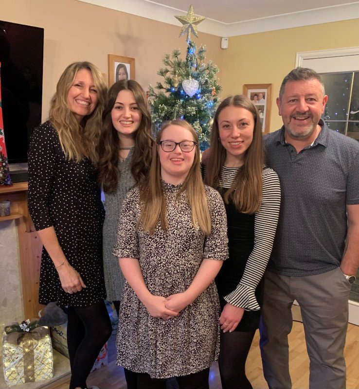 Carmela Falcone, 26, who has Down's syndrome, was given the chance to socialise in a safe space by The i Paper?s Christmas appeal charity Action for Children. She now volunteers to help other young people. Carmela with her family (Photo: Action for Children)