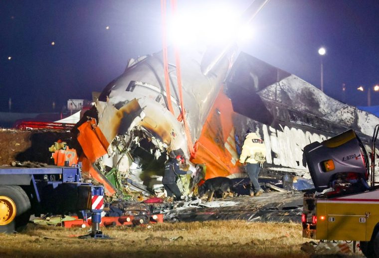 Firefighters and rescue personnel work near the scene where a Jeju Air Boeing 737-800 series aircraft crashed and burst into flames at Muan International Airport in South Jeolla Province, some 288 kilometres southwest of Seoul on December 29, 2024. A Jeju Air plane carrying 181 people from Thailand to South Korea crashed on arrival, smashing into a barrier and bursting into flames, leaving all but two feared dead. (Photo by YONHAP / AFP) / - South Korea OUT / NO ARCHIVES - RESTRICTED TO SUBSCRIPTION USE (Photo by -/YONHAP/AFP via Getty Images)