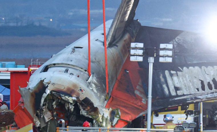 Firefighters and rescue personnel work near the scene where a Jeju Air Boeing 737-800 series aircraft crashed and burst into flames at Muan International Airport in South Jeolla Province, some 288 kilometres southwest of Seoul on December 29, 2024. A Jeju Air plane carrying 181 people from Thailand to South Korea crashed on arrival, smashing into a barrier and bursting into flames, leaving all but two feared dead. (Photo by YONHAP / AFP) / - South Korea OUT / NO ARCHIVES - RESTRICTED TO SUBSCRIPTION USE (Photo by -/YONHAP/AFP via Getty Images)