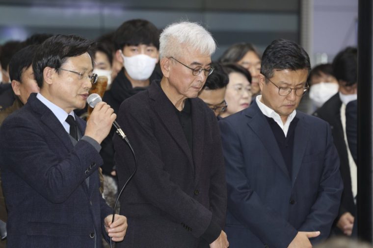 Jeju Air CEO Kim E-bae , left, speaks in apology to relatives of passengers at the Muan International Airport in Muan, South Korea, Sunday, Dec. 29, 2024. (Lee Jin-wook/Yonhap via AP)