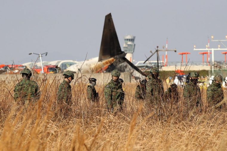 MUAN-GUN, SOUTH KOREA - DECEMBER 29: South Korean soldiers work at the wreckage of a passenger plane at Muan International Airport on December 29, 2024 in Muan-gun, South Korea. A plane carrying 181 people, Jeju Air Flight 7C2216, crashed at Muan International Airport in South Korea after skidding off the runway and colliding with a wall, resulting in an explosion. Early reports said that at least 179 people had died. (Photo by Chung Sung-Jun/Getty Images)