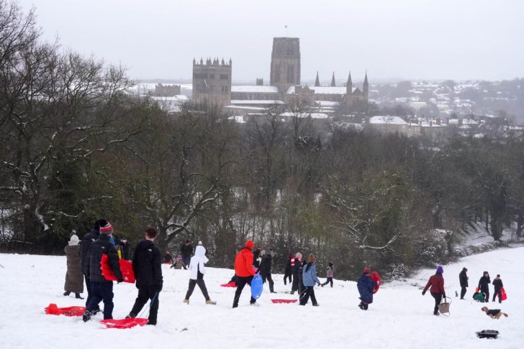 People sledging near Durham Cathedral in Durham. Heavy overnight snow is causing disruption across the UK as the cold start to the new year continues. Picture date: Sunday January 5, 2025. PA Photo. Two amber weather warnings from the Met Office have been put in place in England and Wales, with 3cm to 7cm of snowfall predicted for much of the affected area, mixing with rain at times in lower-lying areas. The Met Office said Bingley, West Yorkshire, had seen 12cm of snow up to 7am on Sunday, with Shap in Cumbria and Capel Curig, Gwynedd, both seeing 10cm. One amber warning for snow and freezing rain, which covers much of Wales and the Midlands as far north as Manchester, is in place until midday on Sunday. See PA story WEATHER Winter . Photo credit should read: Owen Humphreys/PA Wire