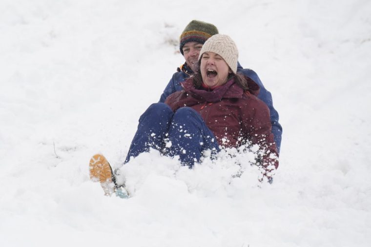 Husband and wife, Bronya and Stefan Meadley, sledge in Studley Royal park in North Yorkshire. Heavy overnight snow is causing disruption across the UK as the cold start to the new year continues. Picture date: Sunday January 5, 2025. PA Photo. Two amber weather warnings from the Met Office have been put in place in England and Wales, with 3cm to 7cm of snowfall predicted for much of the affected area, mixing with rain at times in lower-lying areas. The Met Office said Bingley, West Yorkshire, had seen 12cm of snow up to 7am on Sunday, with Shap in Cumbria and Capel Curig, Gwynedd, both seeing 10cm. One amber warning for snow and freezing rain, which covers much of Wales and the Midlands as far north as Manchester, is in place until midday on Sunday. See PA story WEATHER Winter. Photo credit should read: Danny Lawson/PA Wire