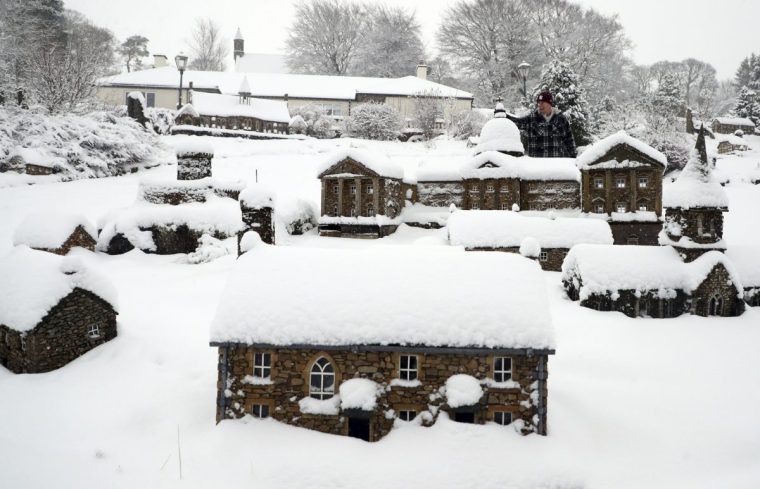 Lowson Robinson is pictured in the heavy snow with his scaled miniature famous landmarks which are located in his garden in Nenthead, England, as the severe weather continues across England, Sunday, Jan. 5, 2025. (AP Photo/Scott Heppell)