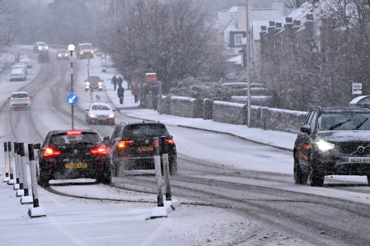 EDINBURGH, SCOTLAND - JANUARY 5: Traffic drives through falling snow on Lanark Road, as wintry conditions close in on the city, on January 5, 2025, in Edinburgh, Scotland. (Photo by Ken Jack/Getty Images)