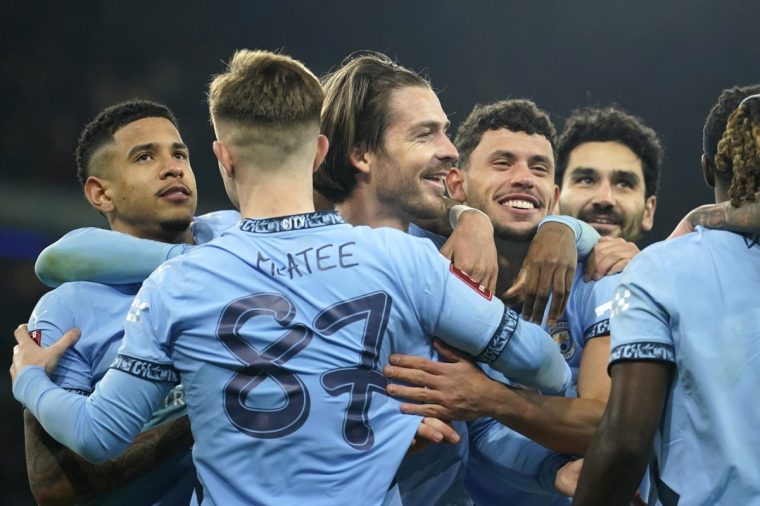 Manchester City's Jack Grealish, centre, celebrates after scoring his side's fourth goal during the English FA Cup soccer match between Manchester City and Salford City at Etihad Stadium in Manchester, Saturday, Jan. 11, 2025. (AP Photo/ Dave Thompson)