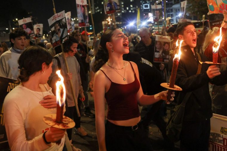 Supporters of Israeli hostages, who were kidnapped during the deadly October 7 2023 attack by Hamas, hold torches as they attend a protest to demand a deal to bring every hostage home at once, amid Gaza ceasefire negotiations, in Tel Aviv, Israel, January 15, 2025. REUTERS/Ronen Zvulun