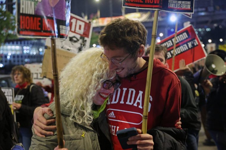 TOPSHOT - Demonstrators embrace each other during a protest calling for action to secure the release of Israelis held hostage in Gaza since the October 2023, in front of the Israeli defence ministry in Tel Aviv on January 15, 2025, amid the ongoing war between Israel and the militant Hamas group. Hamas has approved a Gaza truce and hostage release deal, Palestinian sources close to negotiations said on January 15, after mediator Qatar expressed hope an agreement to end the war could be reached very soon. (Photo by Jack GUEZ / AFP) (Photo by JACK GUEZ/AFP via Getty Images)