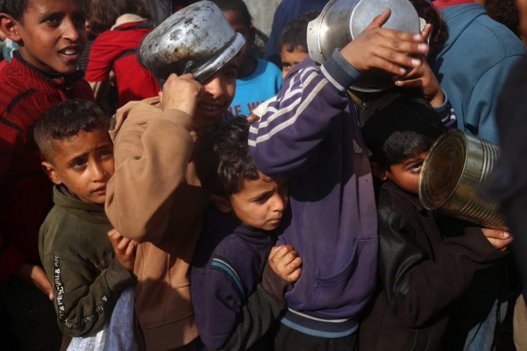 Palestinian children gather to receive aid food being distributed in the Deir al-Balah in the central Gaza Strip on January 16, 2025, following the announcement of a truce amid the ongoing war between Israel and Hamas. (Photo by Eyad BABA / AFP) (Photo by EYAD BABA/AFP via Getty Images)