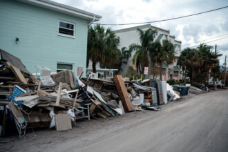 Damaged belongings are piled outside an apartment building on Oct. 5 after Hurricane Helene hit Treasure Island, Fla. Credit: Thomas Simonetti/The Washington Post via Getty Images