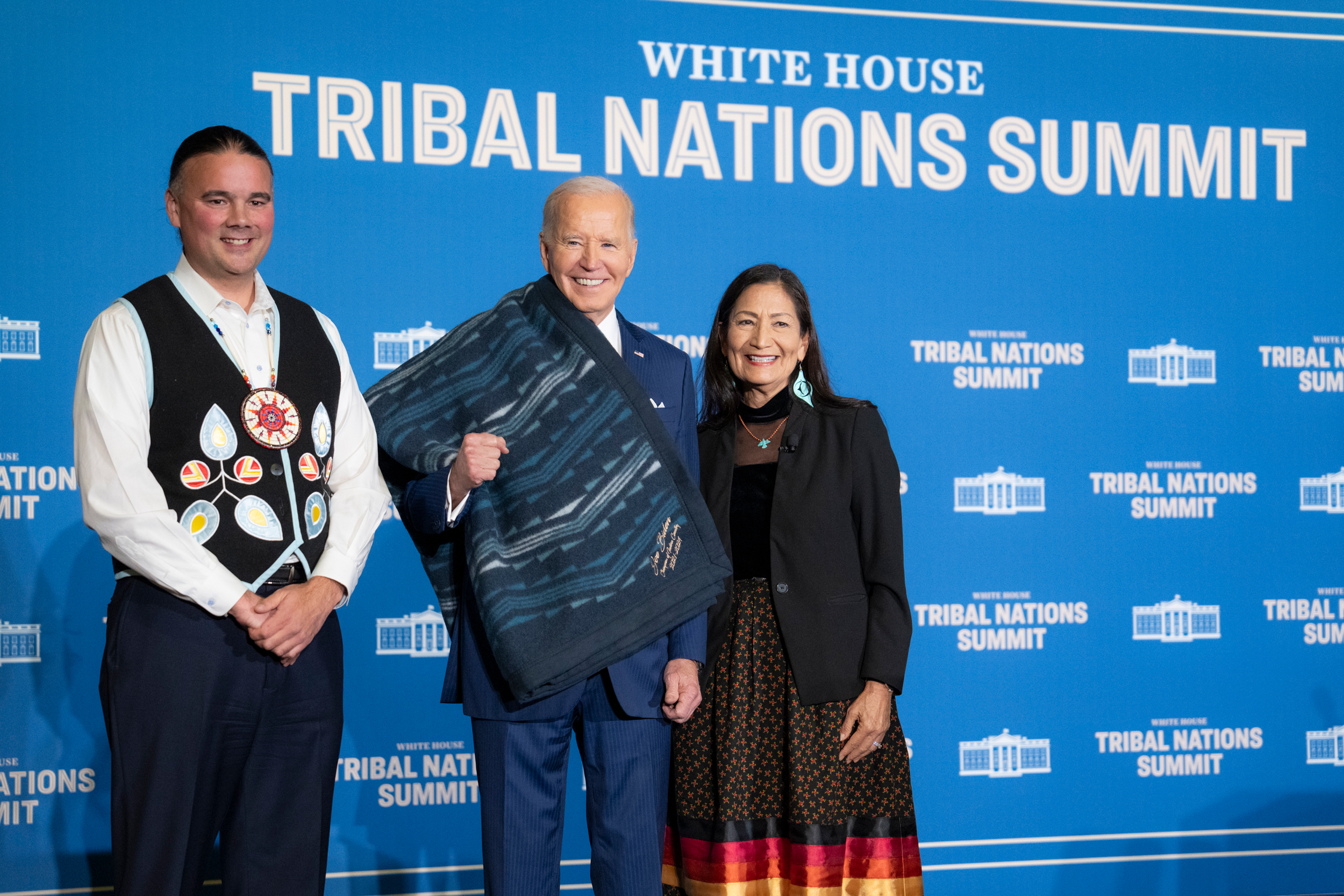 Secretary of the Interior Deb Haaland and Assistant Secretary for Indian Affairs Bryan Newland present a ceremonial blanket to President Joe Biden at the Tribal Nations Summit on Dec. 9 at the Department of the Interior in Washington, D.C. Credit: Adam Schultz/Official White House Photo